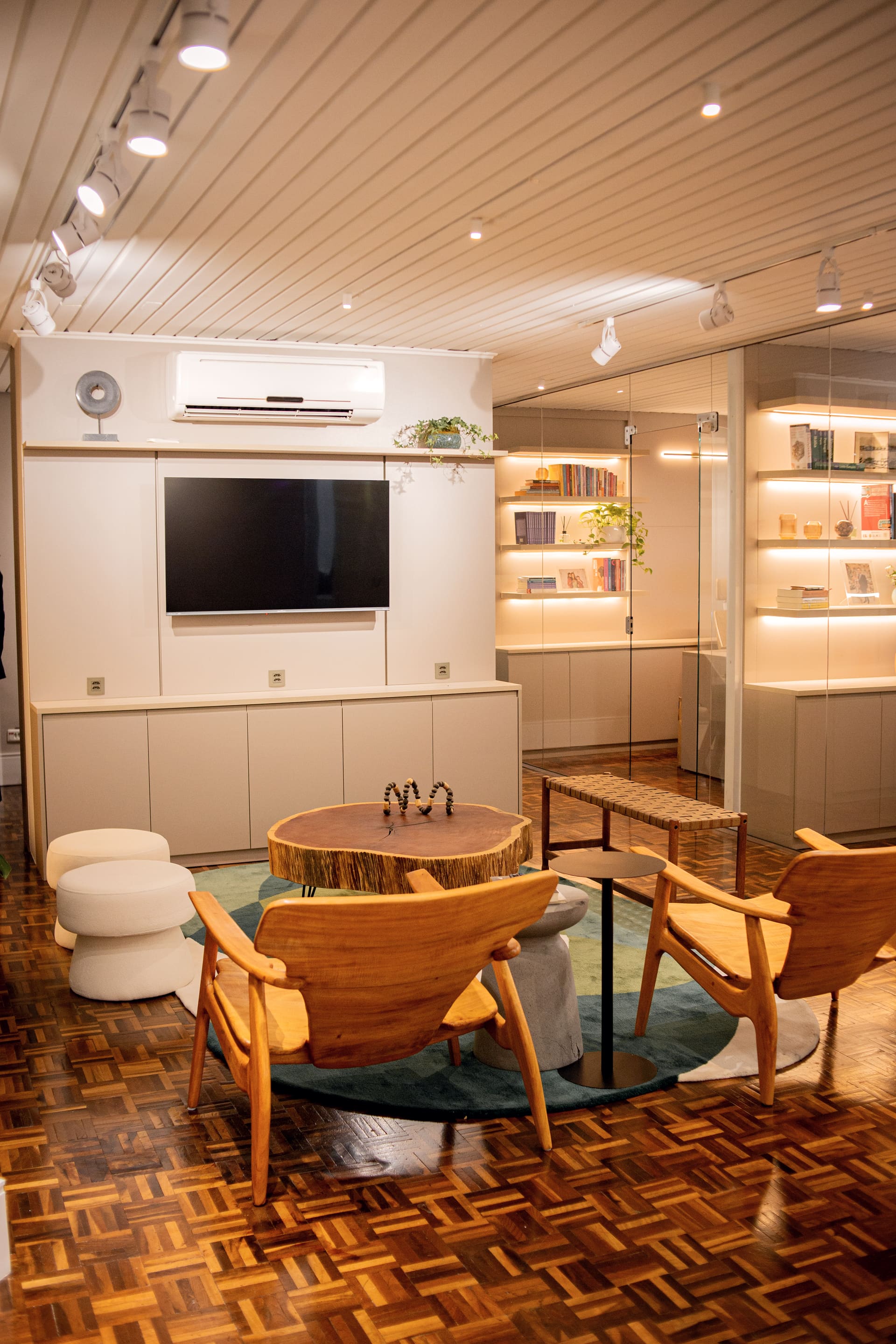 Reception lounge at Fonseca & Bertuzzi Lopes, with wooden armchairs and lit bookshelves